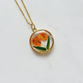 Gold tone dried orange flower resin pendant necklace