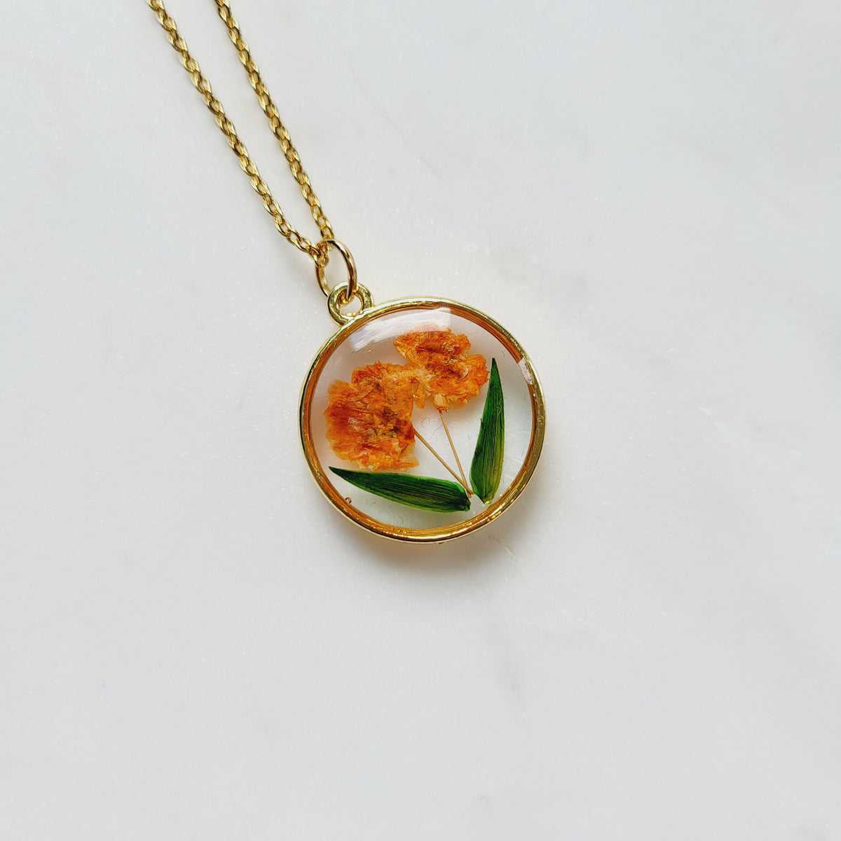 Gold tone dried orange flower resin pendant necklace