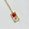 Gold tone dried red flower resin pendant necklace