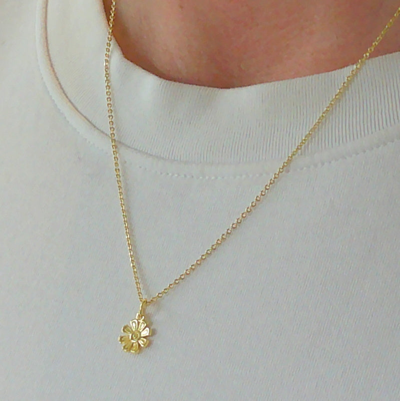 Gold tone flower charm necklace