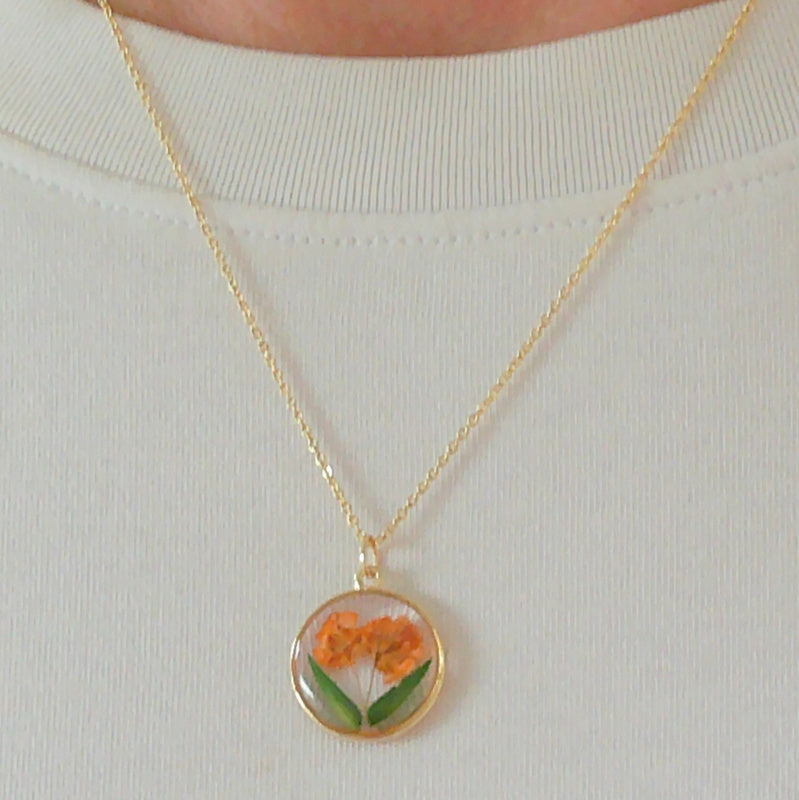 Gold tone dried orange flower resin pendant necklace